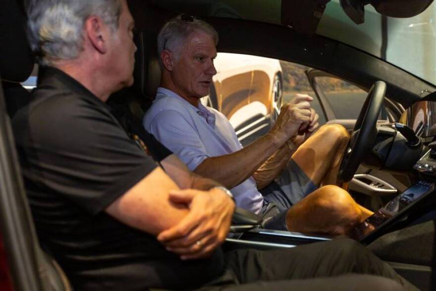 Potential customer Andy Hardin speaks with a salesman inside a Lucid Air Grand Touring model at the Brickell Studio showroom for Lucid, a new high-end electric car company, within Brickell City Centre in Miami, Florida, on Friday, December 2, 2022.