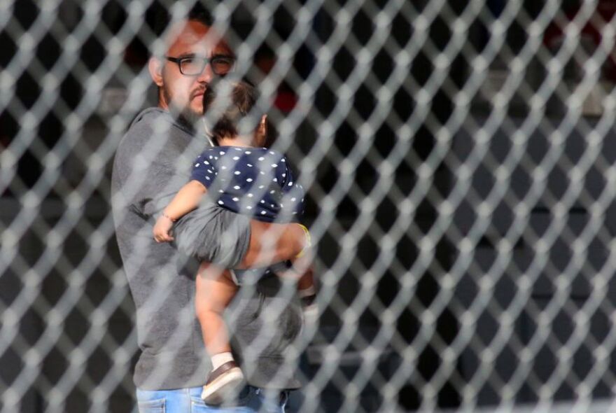 A migrant held an infant under the Paso Del Norte International Bridge in El Paso in March. Border Patrol has since closed the holding area.