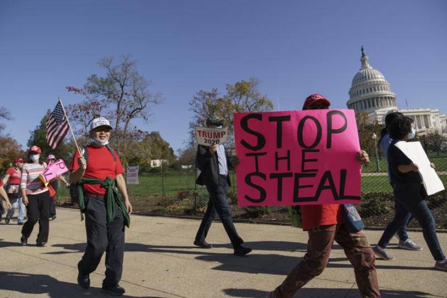  Supporters of President Donald Trump carry flags and signs as they parade past the Capitol in Washington after news that President-elect Joe Biden had defeated the incumbent in the race for the White House, in Washington, Saturday, Nov. 7, 2020.