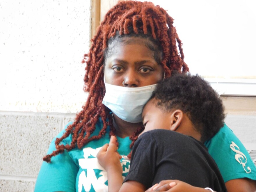  Michelle Colston, holds her four-year-old son Steven, during a news conference in Flint