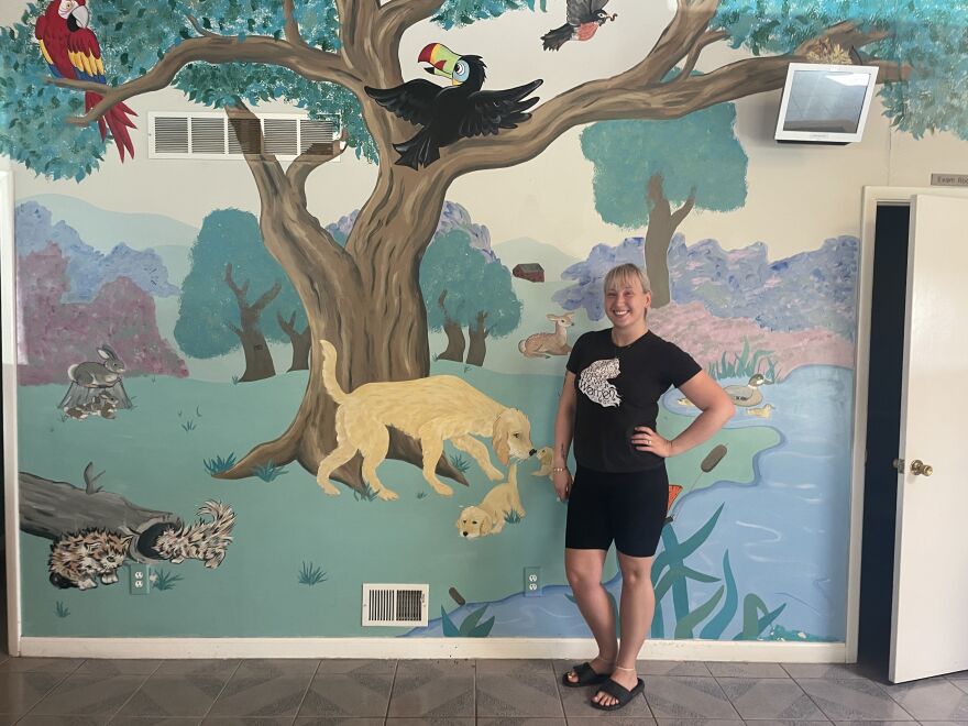  Wish Bone Canine Rescue shelter director Bri Hart stands next to a mural that was a central part of the now-former Kruger Animal Hospital building in west Normal. 