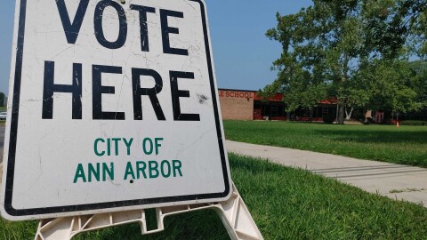 vote here and polling place signs line a street in Ann Arbor, Michigan