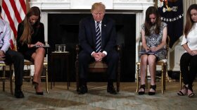 President Donald Trump bows his head during an opening prayer at the start of a listening session with high school students and teachers in the State Dining Room of the White House in Washington, Wednesday, Feb. 21, 2018. (AP Photo/Carolyn Kaster)