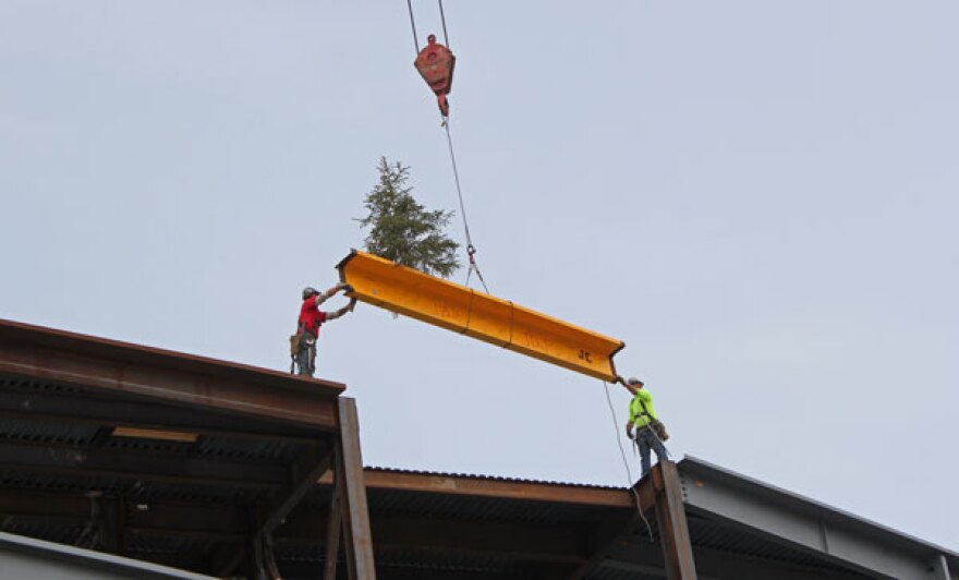 Workers lower the final piece of structural steel into place at the Alaska Airlines Center on the UAA campus. Photo by Josh Edge, APRN - Anchorage.