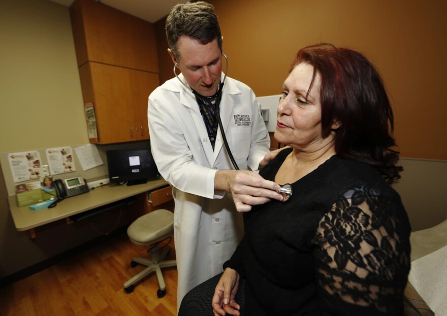 In this Thursday, March 9, 2017, photo, Dr. Michael Russum, left, checks patient Ruby Giron in Denver Health Medical Center's primary care clinic located in a low-income neighborhood in southwest Denver. (David Zalubowski/AP)