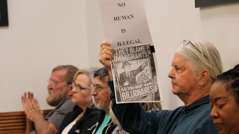 A concerned area resisdent holds up a sign during the Bradford County Commission meeting on Tuesday, April 7, 2026. (Madison Ginsberg/WUFT News)