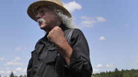 Woodstock veteran Arlo Guthrie reacts after playing a song at the original site of the 1969 Woodstock Music and Arts Fair in Bethel, N.Y., Thursday, Aug. 15, 2019. Guthrie is schedule to play a set on the top of hill nearby but told reporters he wanted to play at least one song on the original 1969 site. Woodstock fans are expected to get back to the garden to mark the 50th anniversary of the generation-defining festival. Bethel Woods Center for the Arts is hosting a series of events Thursday through Sunday at the bucolic 1969 concert site, 80 miles (130 kilometers) northwest of New York City. (AP Photo/Seth Wenig)