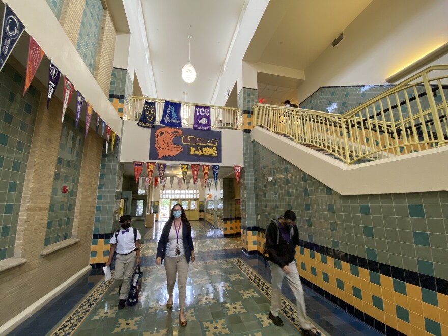  A staff member walks with students in the hallway at the Young Men's Leadership Academy.