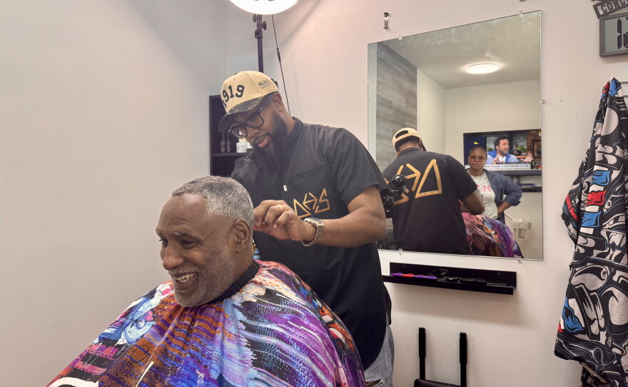 Barber and salon co-owner Nate Williams gives Mario Brown, an OurHAIR trainer, a haircut.