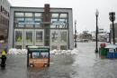 Sandbags hold back the water at the entrance to the Aquarium MBTA station during a storm in 2018. (Robin Lubbock/WBUR, File)