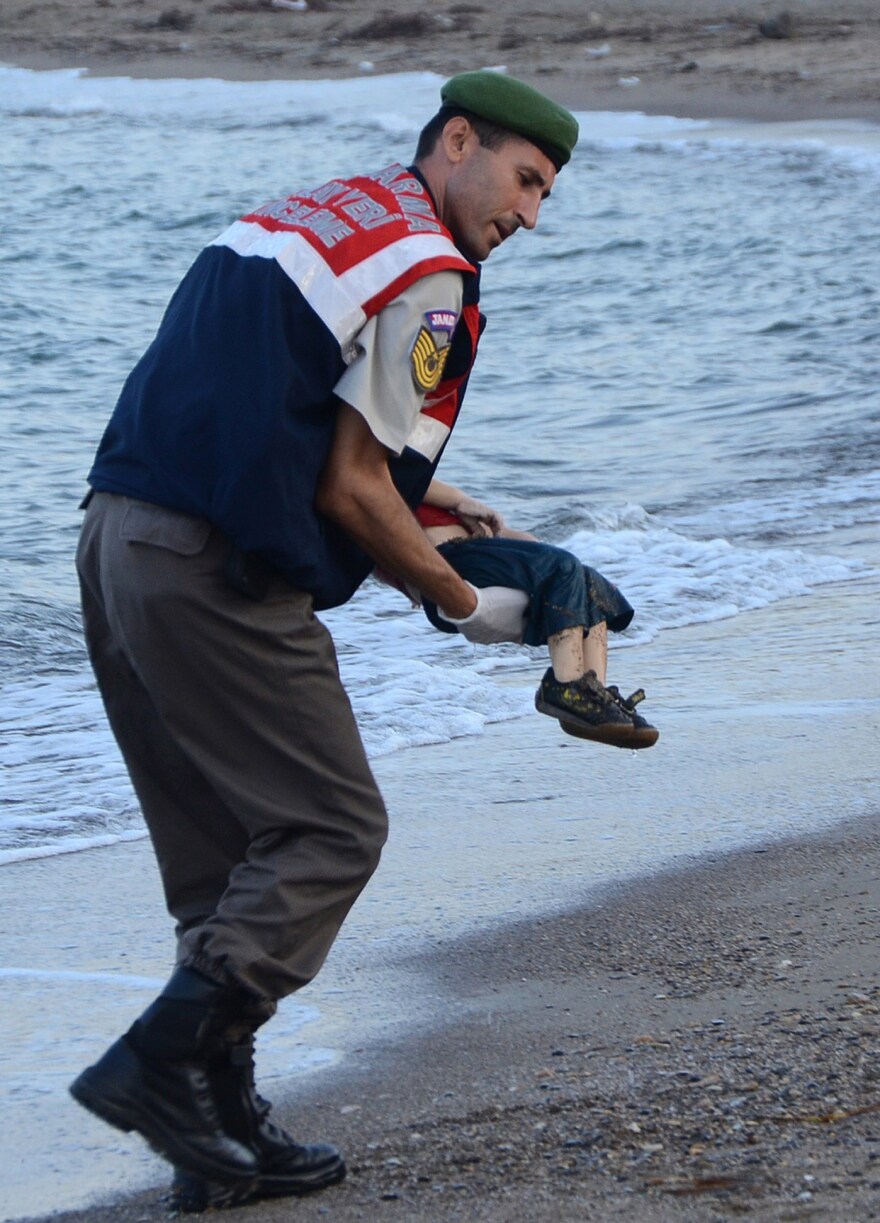 A Turkish police officer carries Aylan Kurdi's dead body off the shores in Bodrum, southern Turkey, on Sept. 2.