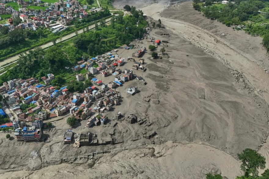 Damaged houses stand precariously near the swollen, debris-choked banks of the Trishuli River after flash floods in Nepal's Nuwakot district on Wednesday, Aug. 26, 2026. (Niranjan Shrestha/AP)
