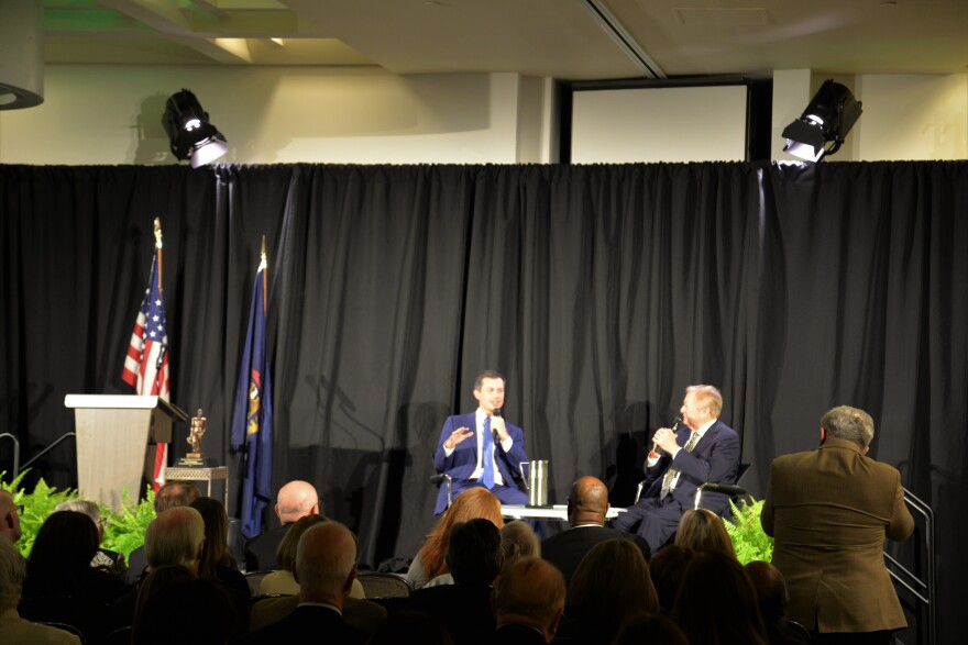 Pete Buttigieg sits next to former Michigan Gov. Jim Blanchard at the Kellogg Center.