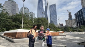 Christina Stanton talks to tourists with NYC's Freedom Tower in the background