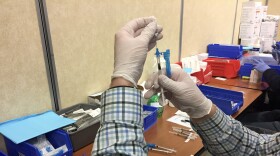 A medical provider preparing a COVID-19 vaccine