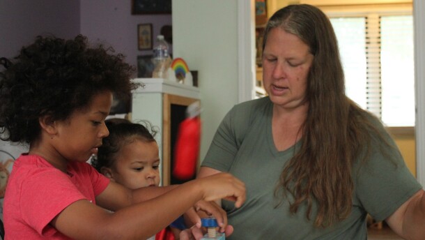 Liz Arnold plays with two children at Just Like Mine Daycare in Lincoln, Nebraska, on DATE. She’s certified to care for up to 10 children in her home, but this summer she is taking care of six.