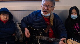 Willie John, a singer and guitarist for "The Bethel Band," plays an appropriate song by John Denver: “Take Me Home, Country Roads”