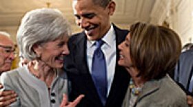 President Barack Obama embraces Health and Human Services Secretary Kathleen Sebelius, left, and House Speaker Nancy Pelosi after signing the health insurance reform bill in the White House.