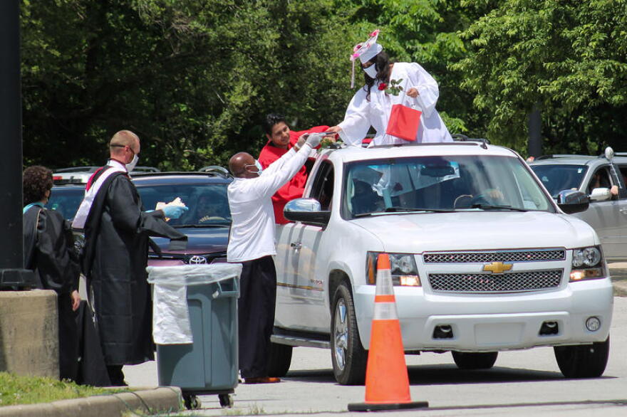 Graduating students and staff wear protective masks during the ceremony. Teachers from Emmerich Manuel High School handed out diplomas and gifts during the drive-thru ceremony on May 30.