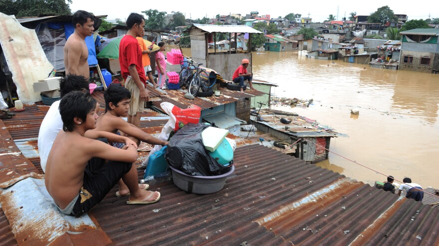 From a rooftop in a Manila suburb today, residents watched water flow through flooded streets.