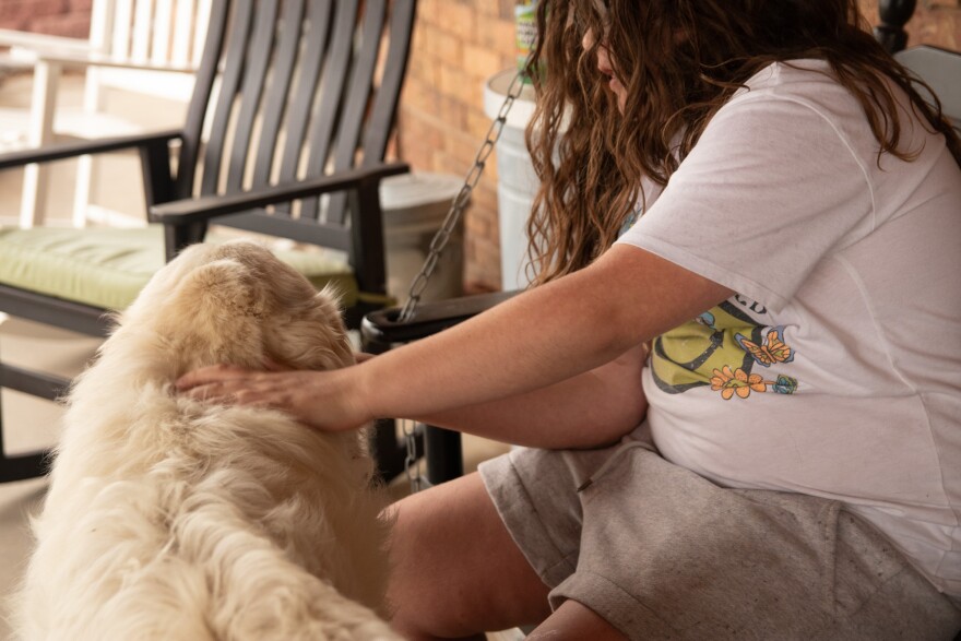 Amy's daughter, who isn't named to protect her medical privacy, pets their Great Pyrenees, Oakley, on a rainy day in rural Kansas.