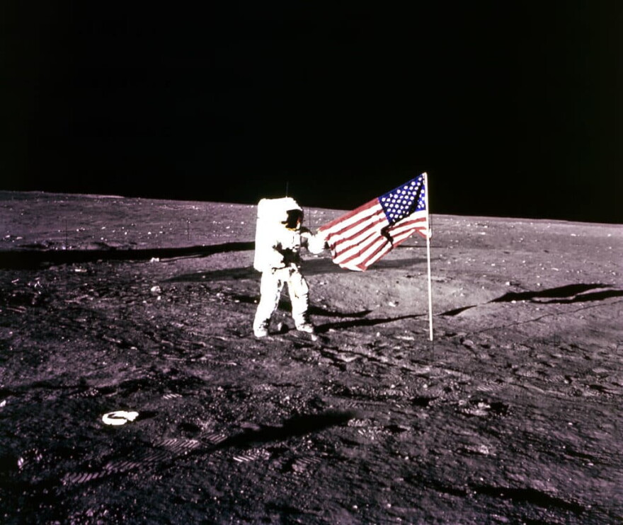 This 19 November 1969 file photo released by NASA shows Apollo 12 Astronaut Charles "Pete"  Conrad standing by the US flag on the Moon. (AFP via Getty Images)