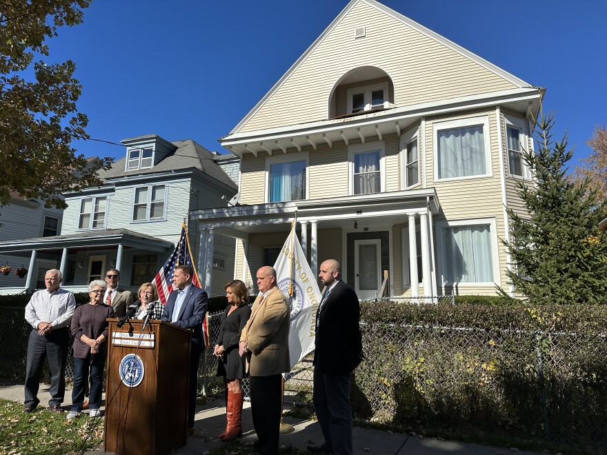 Onondaga County officials stand in front of a home that has been renovated to remove lead paint