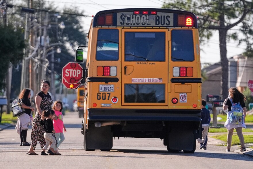 Children disembark from a school bus in a largely Hispanic neighborhood that has been the subject of patrols and detentions by Border Patrol agents, during a federal immigration crackdown in Kenner, La., Wednesday, Dec. 10, 2025.