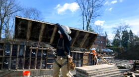 Construction worker moving paneling for the foundation of a building that will be part of Oak Grove - an affordable housing complex in Norwalk.