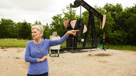 Columbus Oil Company owner Darlene Wallace in the field with a "stripper well," which produces two-and-a-half barrels of oil a day. 
