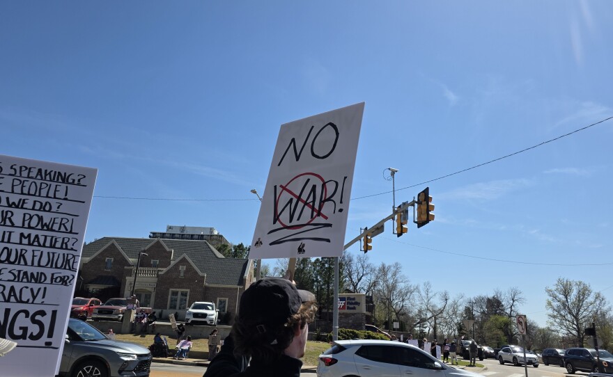 A protester holds up a sign reading "NO WAR" at Tulsa's third "No Kings" rally on March 28, 2026.