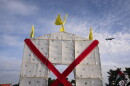 A plane flies over an anti-arch structure lifted up by demonstrators at Memorial Circle to protest the proposed Triumphal Arch, Thursday, Oct. 1, 2026, in Arlington, Va.