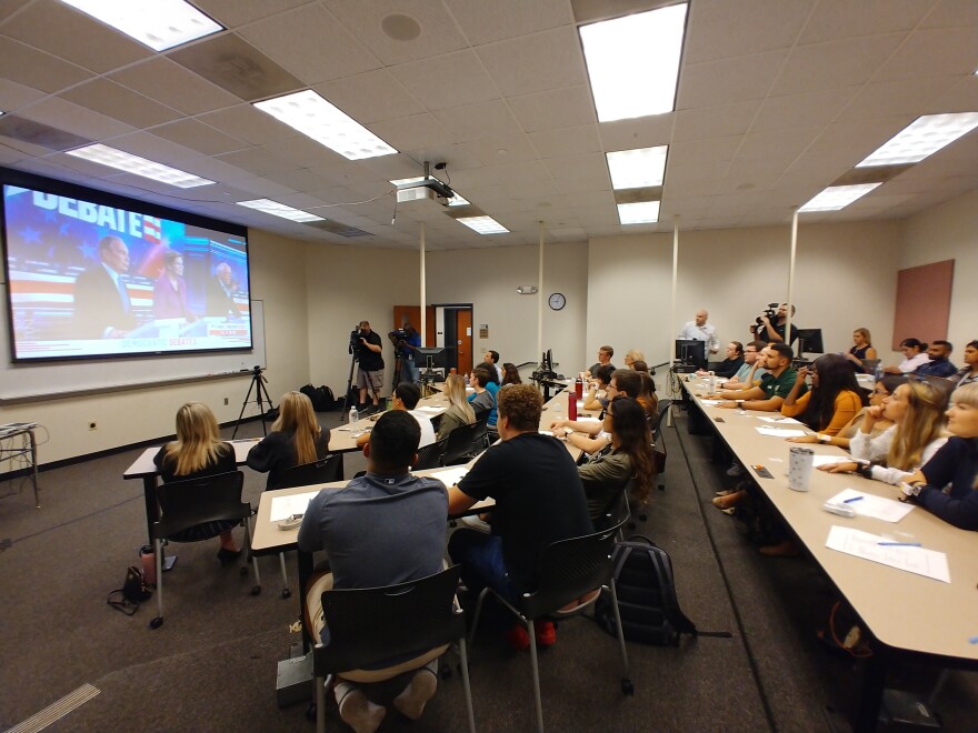 People watch debate on projector screen