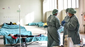 Medical personnel work inside one of the emergency structures that were set up to ease procedures at the hospital of Brescia, Northern Italy, on Tuesday. (Claudio Furlan/LaPresse via AP)