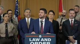 Florida Attorney General James Uthmeier speaks at a podium bearing a “Law and Order” sign during a news conference.