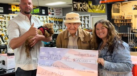Donald, center, holds a $250,000 check presented to him by TikTok content creator Jenelle Marie on Aug. 9. More than $100,000 has been raised since then.
