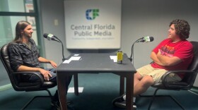 Two young men sit facing each other.