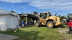 Workers help out at North Fort Myers site Thursday with damage due to winds from Hurricane Helene's outer bands.