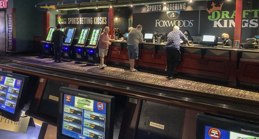 Gamblers place their bets on sports for the first time at Foxwoods Resort Casino in Mashantucket, Conn., Thursday Sept. 30, 2021. The state's two tribal casinos, Foxwoods and Mohegan Sun, were granted the necessary licenses to offer retail sports betting. Both unveiled temporary venues, with places for permanent facilities in the coming weeks, as the first step in rolling out Connecticut's new law legalizing sports and online wagering. (AP Photo/Susan Haigh)