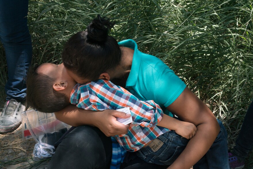Cilian Xiomara Santos, 23, and her son, Erlin Joel Santos, 5, laugh for a moment after they turned themselves in to Customs and Border Protection, as they wait for a bus to pick them up. Many of the migrants feel relieved that they have finally made it to the U.S.