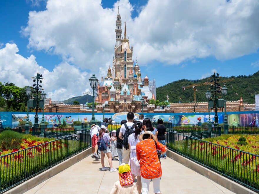 Visitors take photos at the Disneyland Resort in Hong Kong on June 18, 2020.