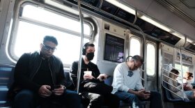 People, some still wearing face masks, ride a subway in Brooklyn in New York City.