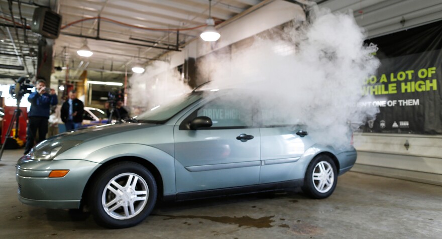 Simulated marijuana smoke billows out of the windows of a car during a demonstration by the Colorado Department of Transportation.