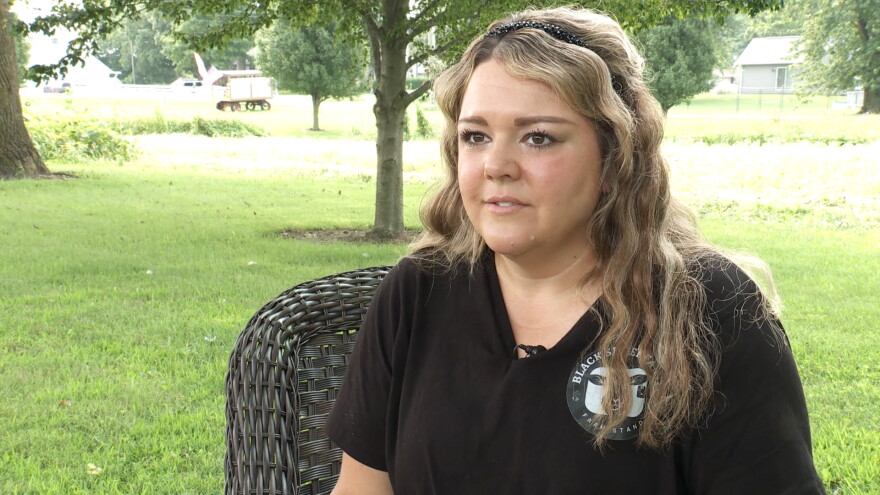 A woman sits for an interview.