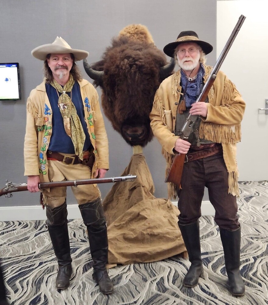 John Hoker (right), of Wheatland, Iowa, is head of the National Congress of Old West Shootists, and he's pictured at their 2024 convention in Davenport, with his 1874 rifle and the head of a 1,800-pound buffalo he shot about 15 years ago.