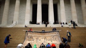 Volunteers help roll up a giant banner printed with the Preamble to the United States Constitution during a demonstration against the Supreme Court's Citizens United ruling at the Lincoln Memorial on the National Mall October 20, 2010 in Washington, DC. The rally at the memorial was organized by brothers Laird and Robin Monahan who spent the last five months walking from San Francisco, California, to Washington to protest the court decision, which overturned the provision of the McCain-Feingold law barring corporations and unions from paying for political ads made independently of candidate campaigns.  (Chip Somodevilla/Getty Images)