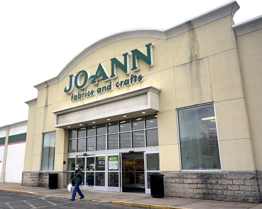 a woman exits a joann fabric and craft store
