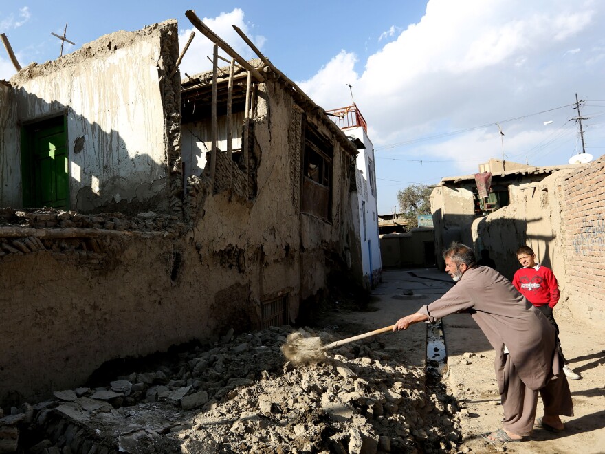 An Afghan man clears rubble from a damaged house after the earthquake shook the region. The epicenter was approximately 150 miles from Kabul, Afghanistan.