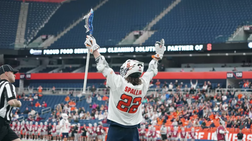 SU attackman Joey Spallina (22, white) celebrates after his milestone point during SU’s 16-12 win over Colgate on Saturday.