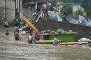 Workers transfer construction materials to higher grounds along a swollen river due to enhanced rains brought about by Typhoon Doksuri on Thursday, July 27, 2023, in Marikina city, Philippines. Typhoon Doksuri lashed northern Philippine provinces with ferocious wind and rain Wednesday, leaving several people dead and displacing thousands of others as it blew roofs off houses, flooded low-lying villages and triggered dozens of landslides, officials said.